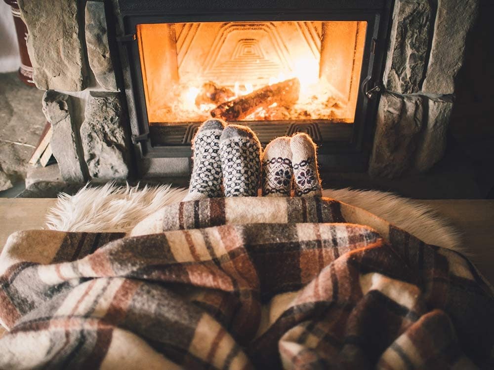 Couple cozying up to fireplace