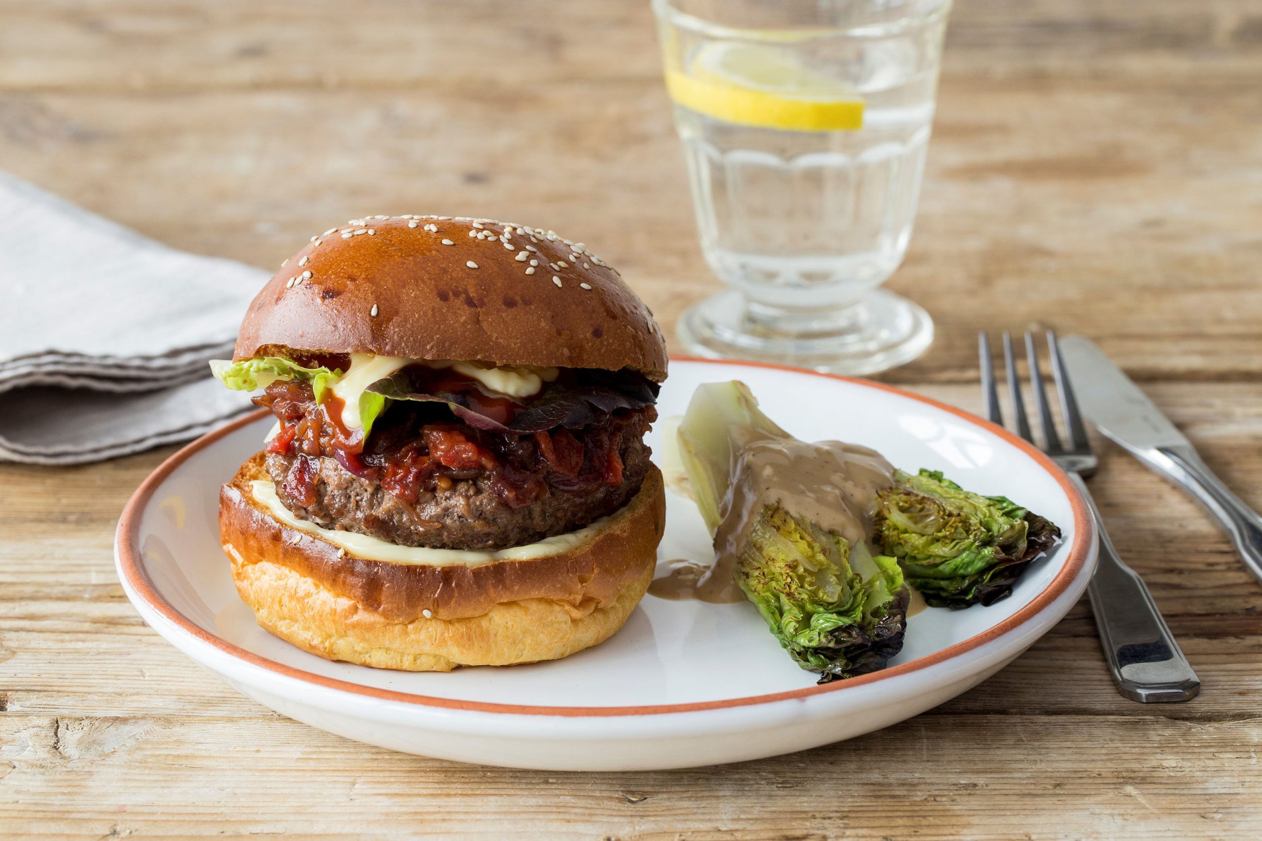 Juicy Lucy Burger with Tomato-Onion Jam and Charred Baby Lettuce