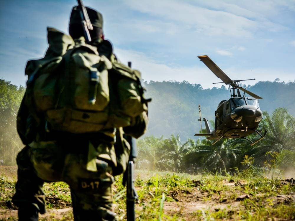 Soldier watching helicopter in jungle