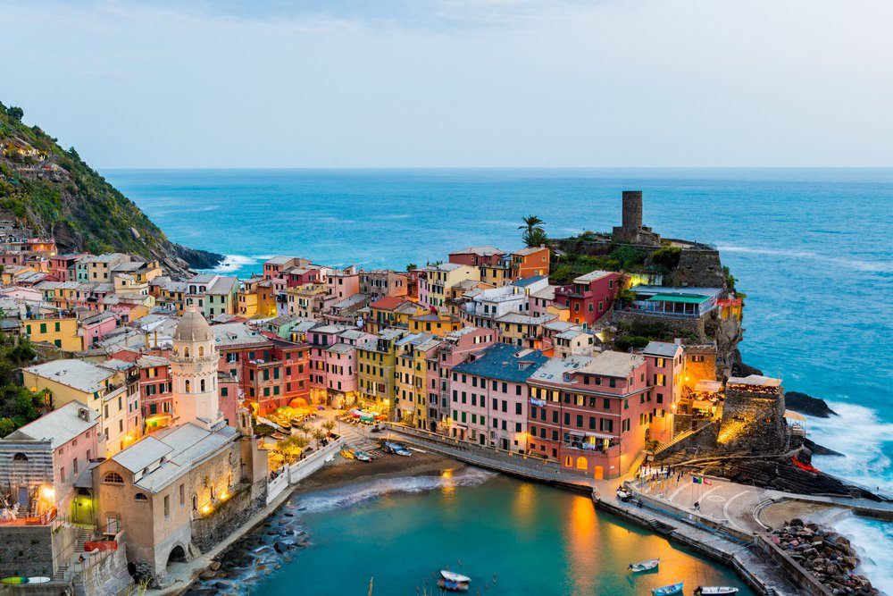 view of famous travel landmark destination Vernazza, small mediterranean old sea town with harbour coast and castle,Cinque terre National Park, Liguria, Italy. Summer early morning with street lights