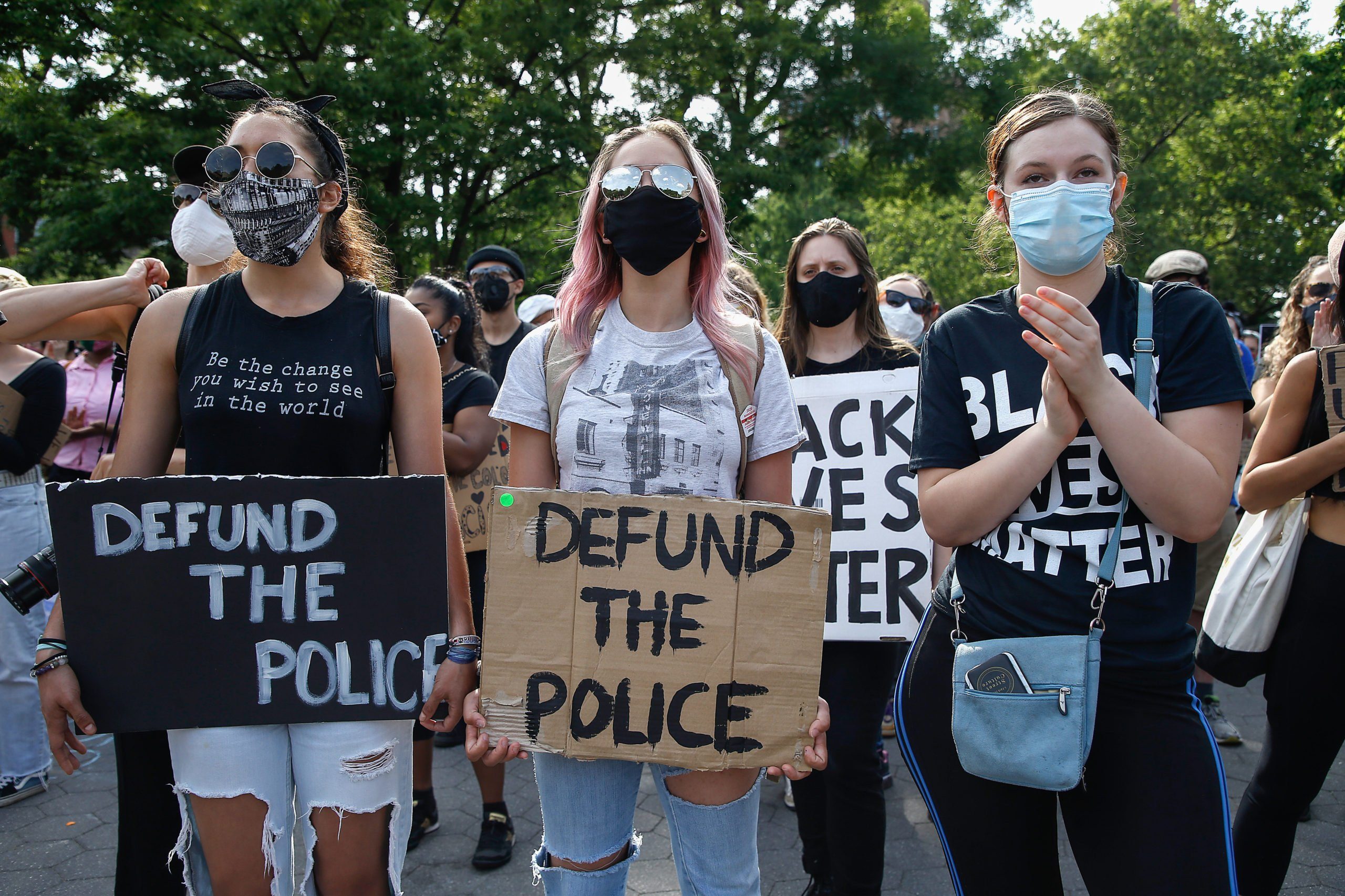 Demonstrators hold placards saying 'Defund The Police'...